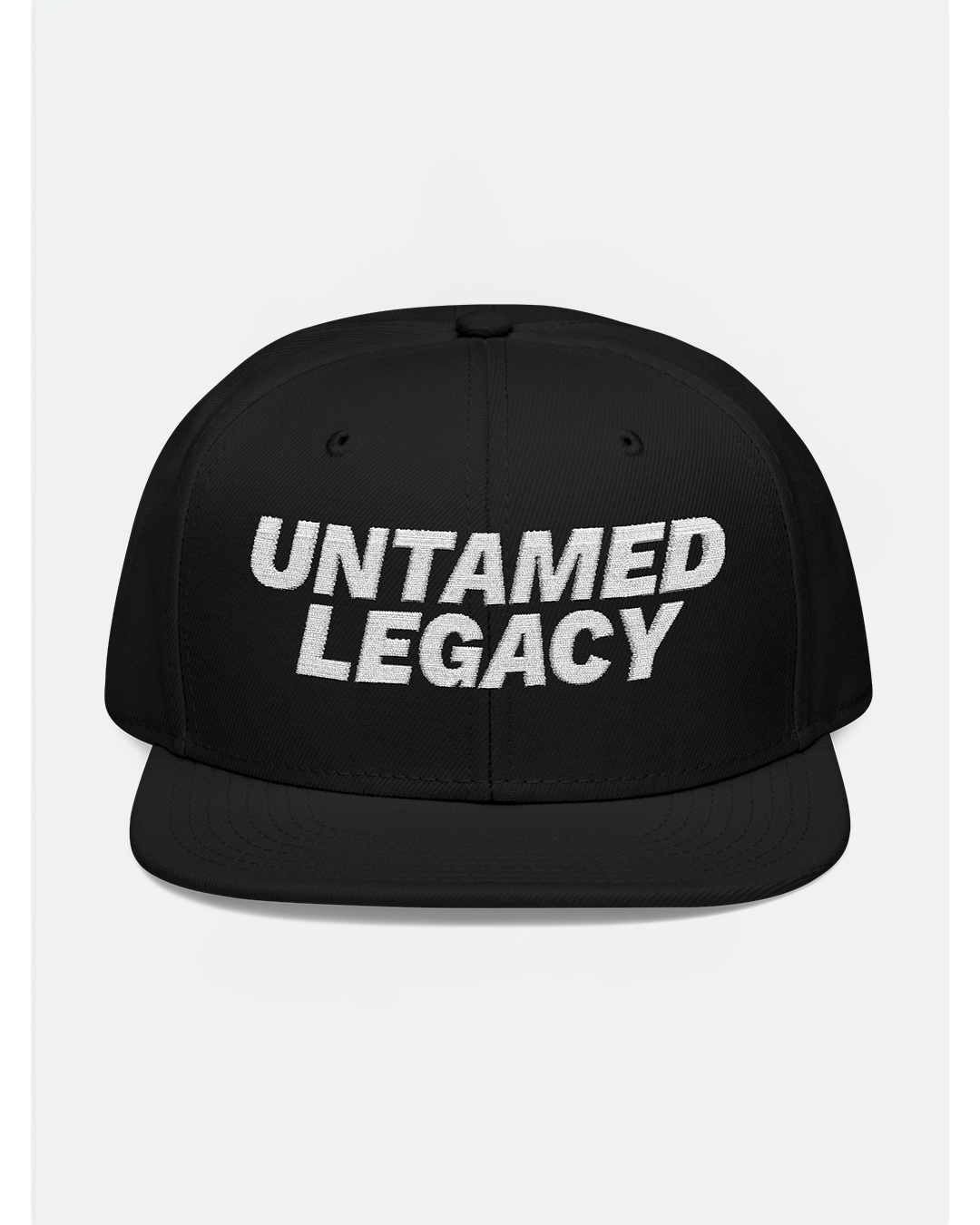 Sleek black snapback hat with clean white embroidered “Untamed Legacy” logo — subtle but strong streetwear identity.
