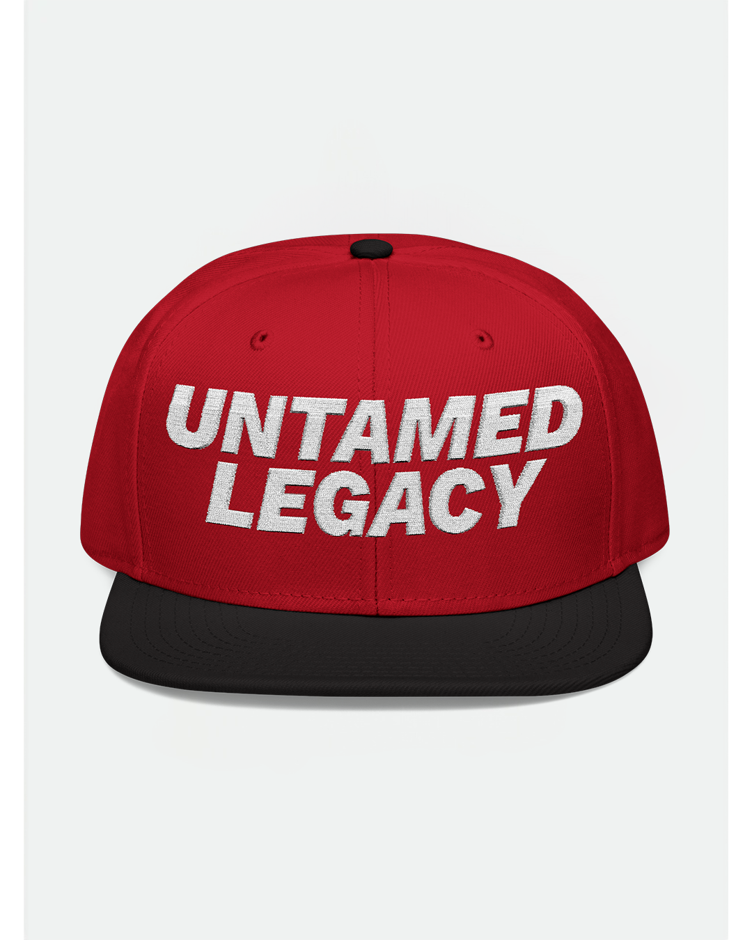 Bold red and black snapback hat with white embroidered “Untamed Legacy” logo, designed for standout streetwear styling.