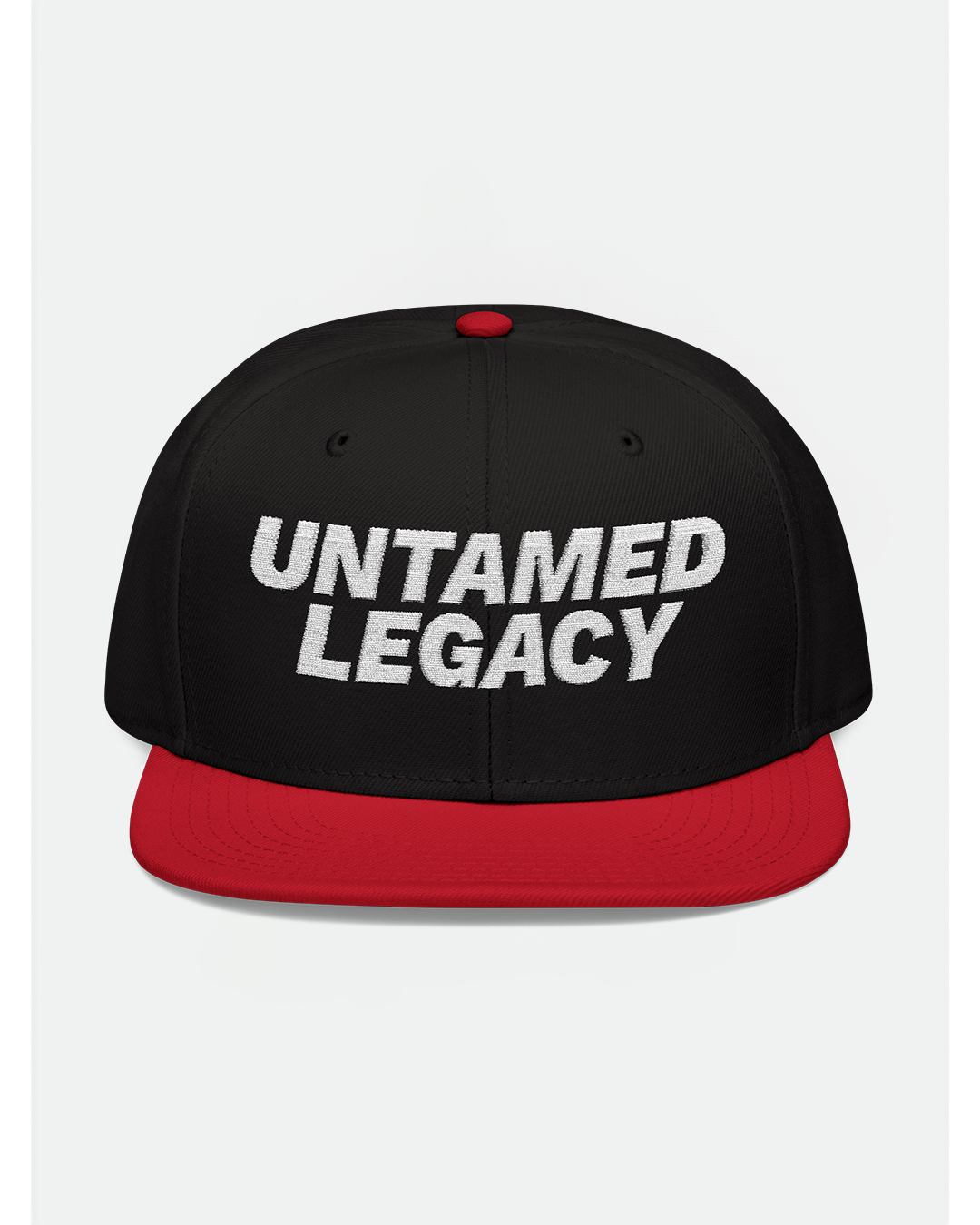 Eye-catching black snapback cap with red brim and white “Untamed Legacy” embroidery — a statement piece for bold looks.